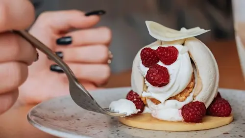 Elegant dessert with cream and raspberries showing balanced flavours